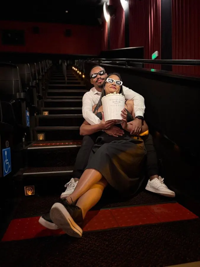 Casal sentado na escada do cinema com pipoca