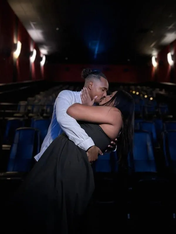 Casal abraçado na sala de cinema